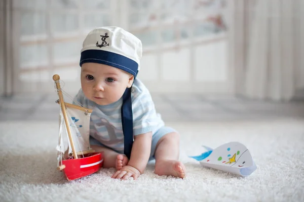 Baby jongetje, spelen met bootje en visje op hom — Stockfoto