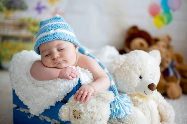 Bambino con cappello a maglia, che dorme con simpatico orsacchiotto — Foto Stock
