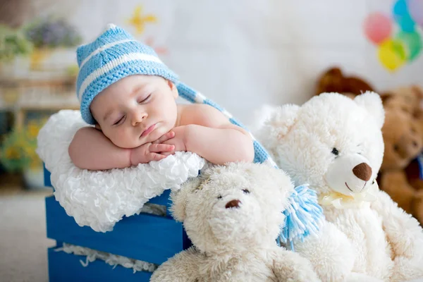 Μικρό αγοράκι με πλεκτό καπέλο, στον ύπνο με χαριτωμένο αρκουδάκι — Φωτογραφία Αρχείου