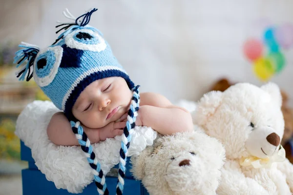 Menino com chapéu de malha, dormindo com ursinho de pelúcia bonito — Fotografia de Stock