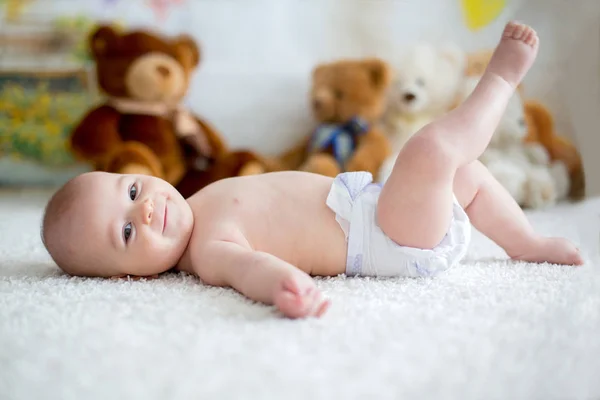 Menino brincando em casa com brinquedos de ursinho macio — Fotografia de Stock