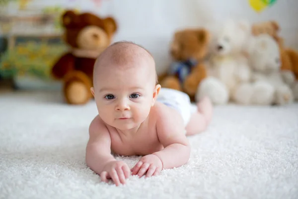 Menino brincando em casa com brinquedos de ursinho macio — Fotografia de Stock