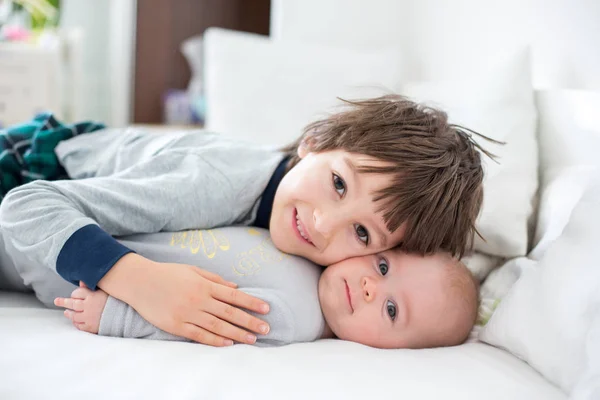 Двое детей, ребенок и его старший брат в постели по утрам , — стоковое фото