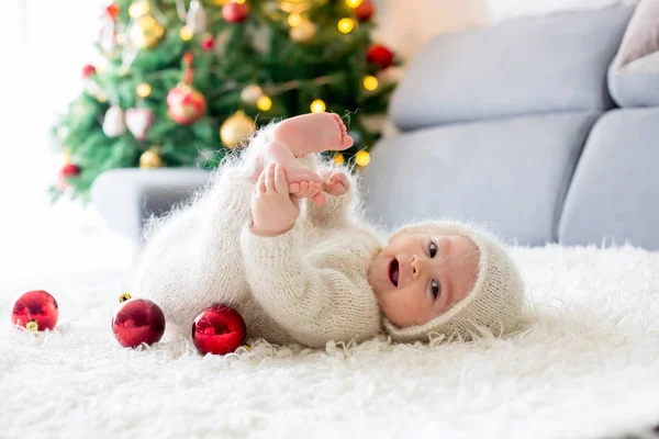 Malý chlapeček v bílé pletené onesie, hrát s a otevření — Stock fotografie