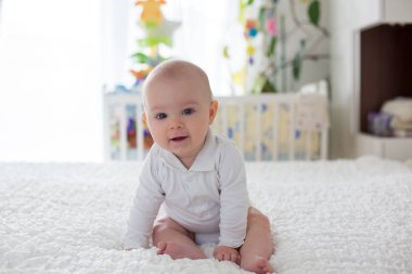Evde yatakta peluş oyuncak ile oynarken küçük oğlu, yürümeye başlayan çocuk, 