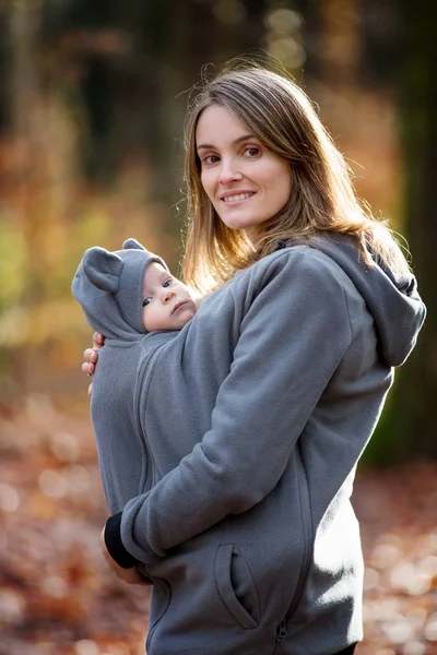 Matka, nesoucí její chlapeček v praku, venku — Stock fotografie