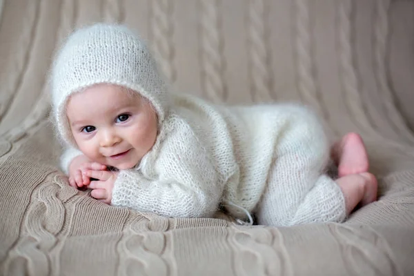 Beatiful bebé niño en paños de punto blanco y sombrero, buscando curio —  Fotos de Stock