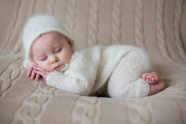 Mooie babyjongen in witte gebreide kleding en hoed, slapen — Stockfoto