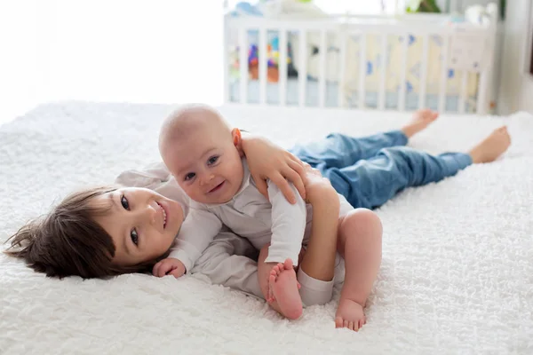 Kleine peuter jongen, spelen met zijn broertje thuis — Stockfoto