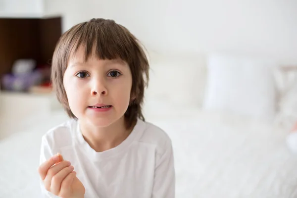 Pequeño niño sonriente mano señalando su primer diente de leche de bebé — Foto de Stock