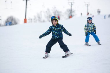 Mavi ceketli şirin küçük okul öncesi çocuk Kayak mutlu bir şekilde üzerine bir 