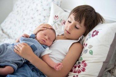 Güzel çocuk, hassasiyet ile sarılma ve onun yeni doğan Bebek Bakımı