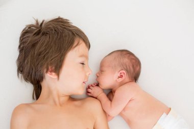 Güzel çocuk, hassasiyet ile sarılma ve onun yeni doğan Bebek Bakımı