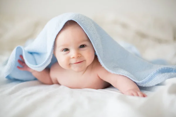 Милий маленький хлопчик, розслабляється в ліжку після ванни, усміхнене щастя — стокове фото