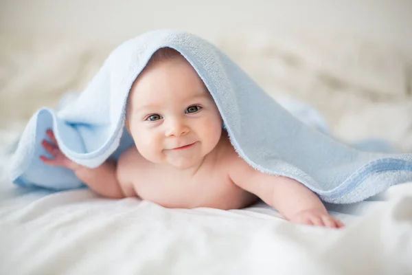 Niedliche kleine Junge, entspannen im Bett nach dem Bad, lächeln glücklich — Stockfoto