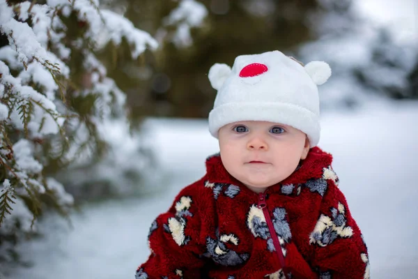 Açık havada oturup karda gülümseyen küçük şirin bebek çocuk — Stok fotoğraf