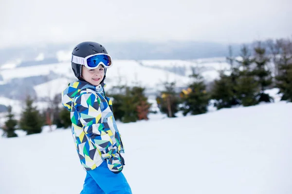 Mignon petit enfant d'âge préscolaire en veste bleue, skier heureux sur un — Photo