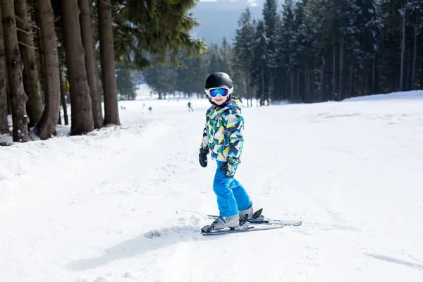 Lindo niño preescolar en chaqueta azul, esquiando felizmente en un — Foto de Stock
