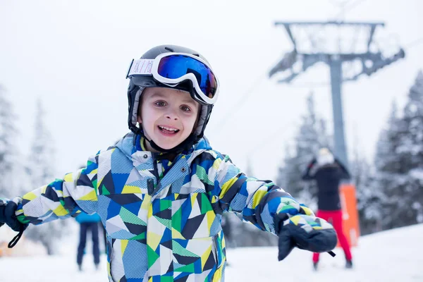 Lindo niño preescolar en chaqueta azul, esquiando felizmente en un —  Fotos de Stock