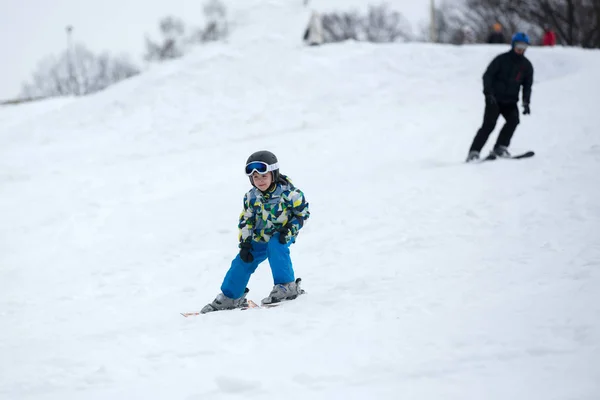 Мила маленька дошкільна дитина в блакитній куртці, катається на лижах щасливо на — стокове фото
