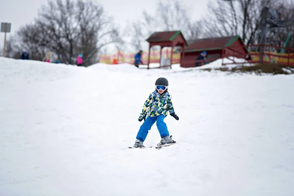 Słodkie małe dziecko przedszkola w Błękitnej Kurtki, szczęśliwie na narty — Zdjęcie stockowe