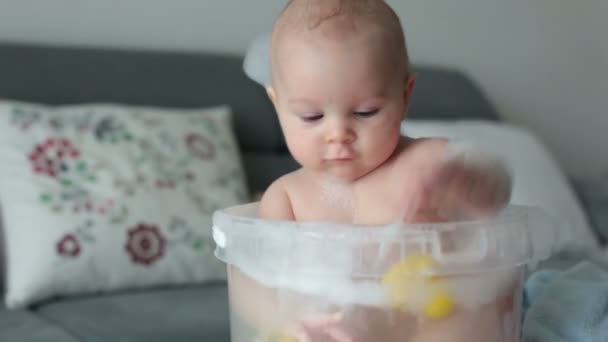 Lindo Niño Cuatro Meses Jugando Cubo Lleno Agua Bañándose Jugando — Vídeos de Stock