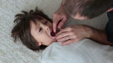 Baba, oğlunun diş çekmeye çalıştığını çocuk oturup yatak, diş çekme baba