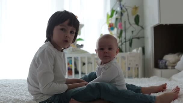 Kleiner Junge Der Mit Seinem Kleinen Bruder Hause Schlafzimmer Spielt — Stockvideo