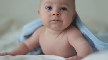 Şirin bebek çocuk, rahatlatıcı banyo sonra yatakta mutlu bir şekilde gülümseyerek, gündüz