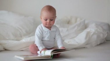 Yatakta oturmuş aşçı evde, renkli resimlerle bakarak küçük oğlu,