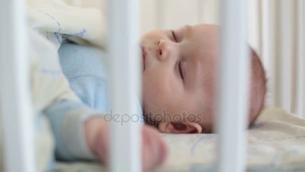 关闭一个小男孩的脚趾和手指 婴儿躺在婴儿床上 — 图库视频影像