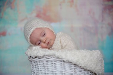 Küçük şirin bebek çocuk, el yapımı örgü beyaz teddy giyinmiş olmak