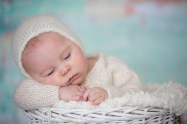 Küçük şirin bebek çocuk, el yapımı örgü beyaz teddy giyinmiş olmak