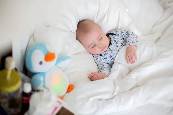 Niño enfermo acostado en la cama con fiebre, descansando en casa — Foto de Stock