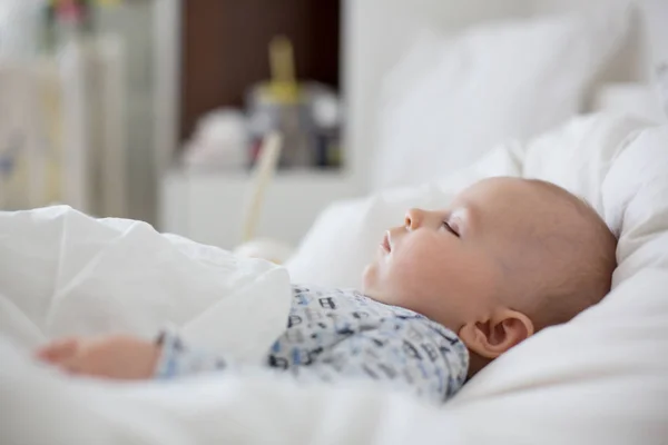 Niño enfermo acostado en la cama con fiebre, descansando en casa — Foto de Stock