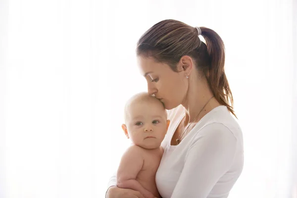 Mãe, segurando seu menino doente, bebê triste, isolado em branco — Fotografia de Stock