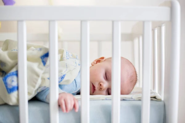 Close up van een baby jongetje slapen, baby liggend in baby cot — Stockfoto
