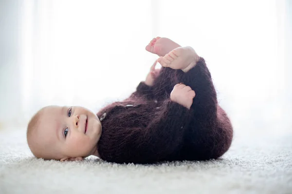 Být malý roztomilý chlapeček, oblečený v ručně pletený hnědý medvídek — Stock fotografie
