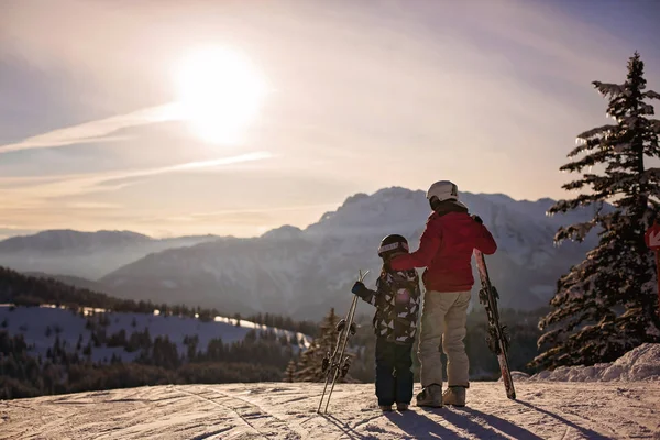 Madre e hijo, niño en edad preescolar, esquiando juntos al atardecer en au — Foto de Stock