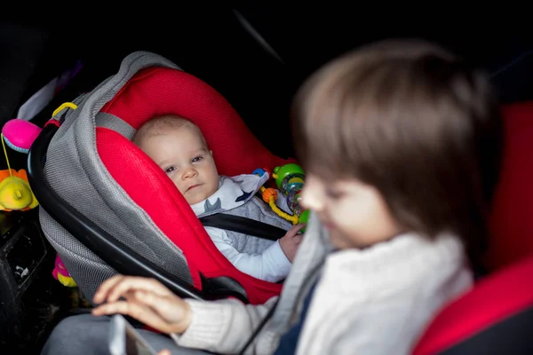 Pequeño niño y su hermano mayor, viajando en asientos de coche, g —  Fotos de Stock