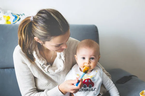 Mamma, mata hennes pojke med mosade pumpking — Stockfoto