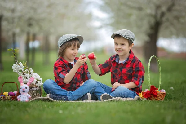 Two children, boy brothers, having fun with easter eggs in the p — Stock Photo, Image
