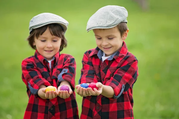 Dos niños, hermanos varones, divirtiéndose con huevos de Pascua en la p — Foto de Stock