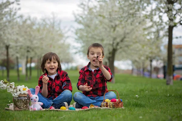 Two children, boy brothers, eating chocolate bunnies and having — Stock Photo, Image