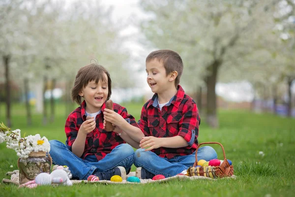 Two children, boy brothers, eating chocolate bunnies and having — Stock Photo, Image