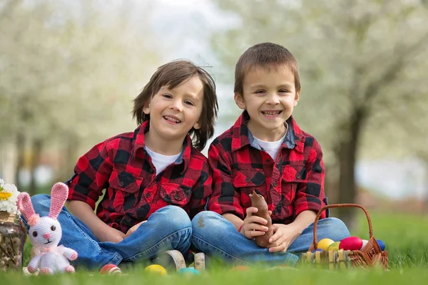 Two children, boy brothers, eating chocolate bunnies and having — Stock Photo, Image