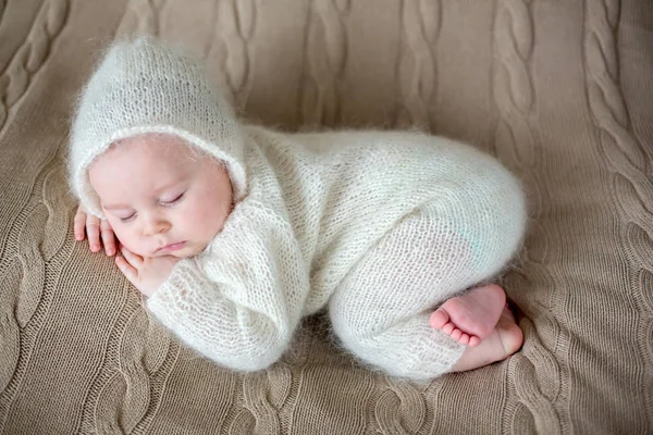 Beatiful baby boy in white knitted cloths and hat, sleeping — Stock Photo, Image