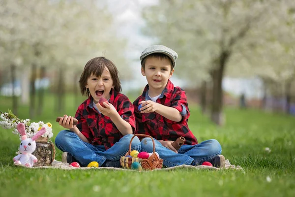 Two children, boy brothers, eating chocolate bunnies and having — Stock Image Two children, boy brothers, eating chocolate bunnies and having Stock Photo