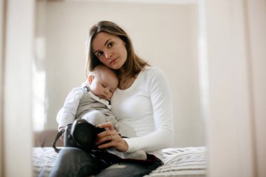 Genç anne, şefkatle tutarak onun uyku yürümeye başlayan çocuk