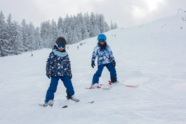 Lindos niños preescolares, esquí en la estación de invierno austriaca en una c — Foto de Stock